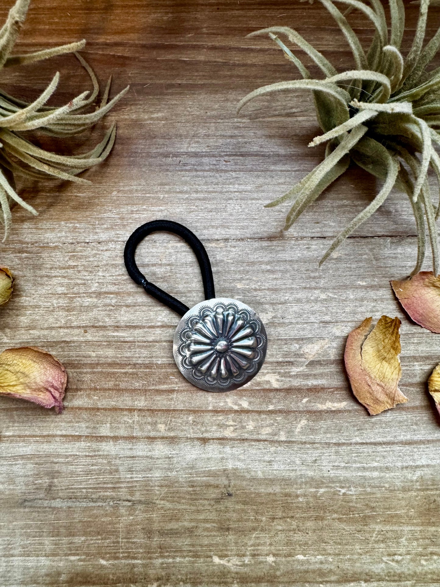 Handmade sterling silver hair tie with a detailed stamped concho design. Each piece is unique due to individual stamping. Western style accessory, made in the USA. Curated by The Bijoux FAB.