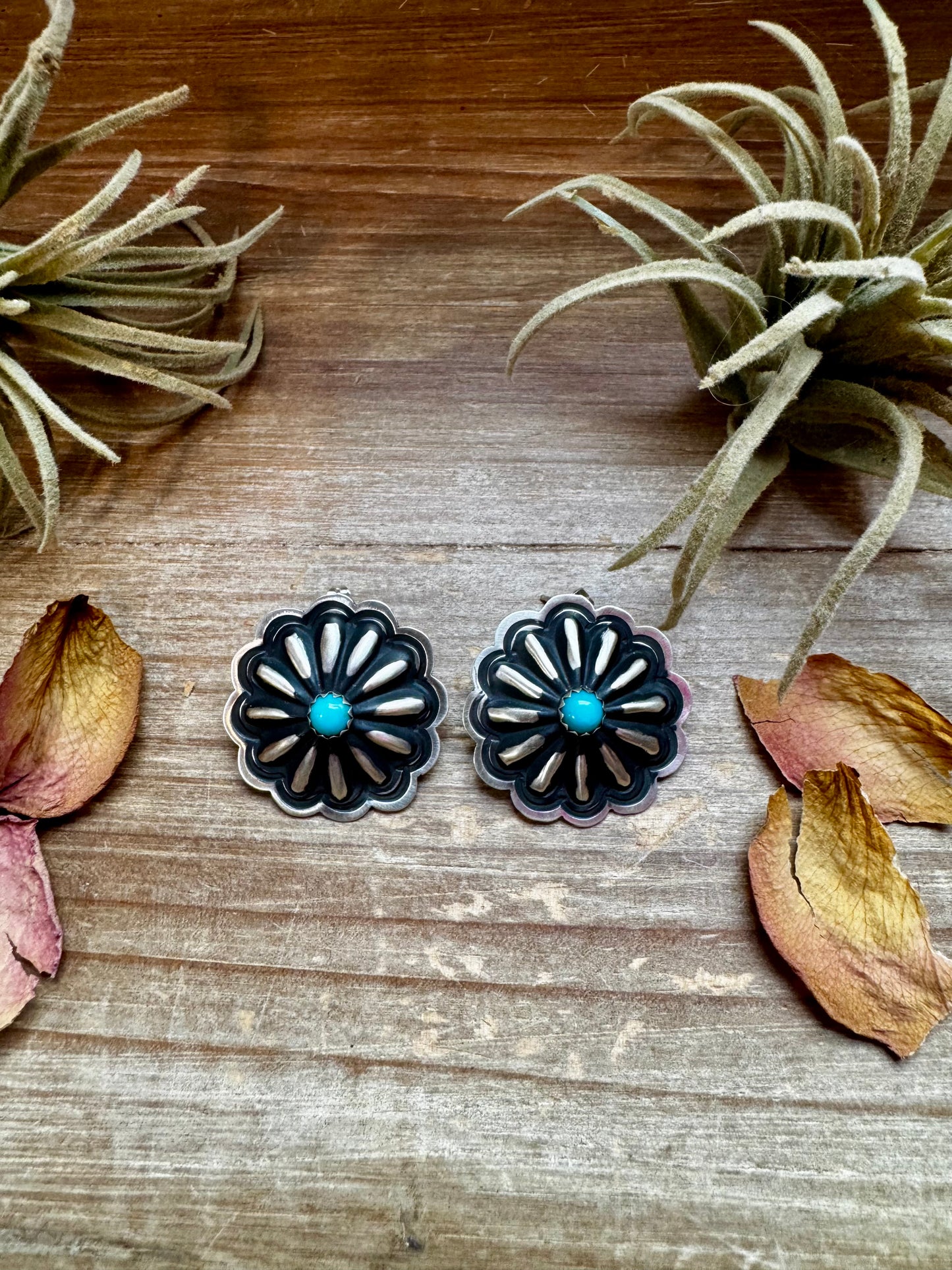 Large handcrafted concho stud earrings featuring genuine turquoise stones set in detailed sterling silver. Made in the USA. Lightweight and naturally unique. Curated by The Bijoux FAB.