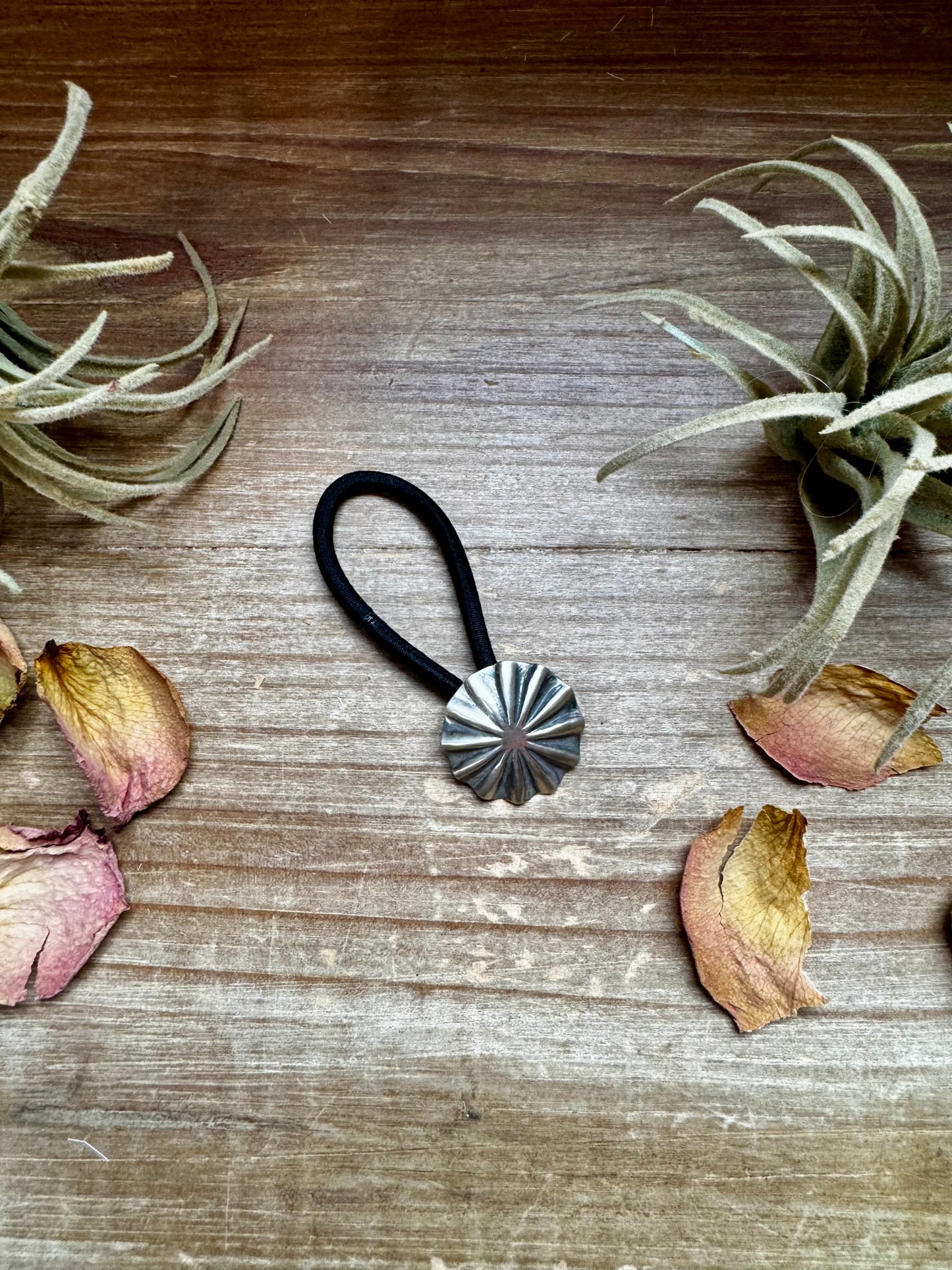 Small sterling silver hair tie featuring a hand-stamped concho design. Lightweight, durable, and stamped STERLING. Handmade in the USA. Each pattern is slightly different. Curated by The Bijoux FAB.