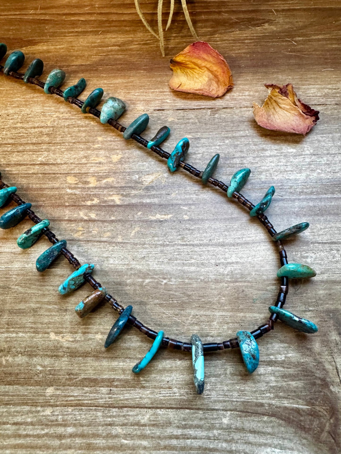 Handmade 30-inch necklace with 3mm dark shell beads and a real turquoise teardrop pendant. Silver-plated finish. Every turquoise stone is unique. Made in the USA by The Bijoux FAB. Limited quantity available.