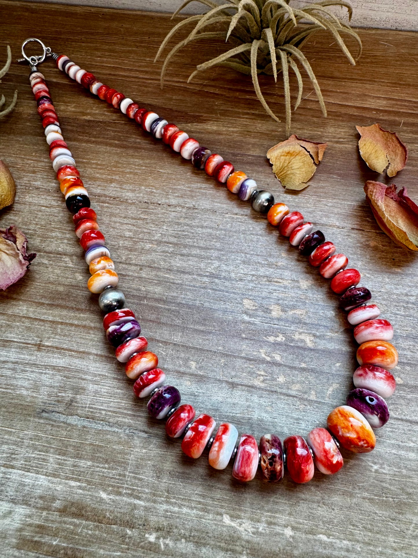 22-inch handmade necklace with vibrant spiny oyster beads in orange, red, purple, and purple wampum shell, spaced with hematite and two large sterling silver pearls