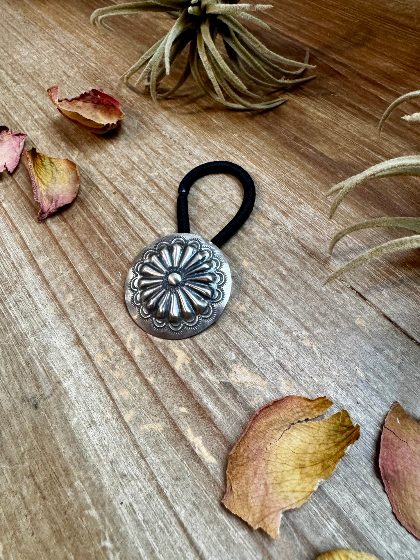 Handmade sterling silver hair tie with a detailed stamped concho design. Each piece is unique due to individual stamping. Western style accessory, made in the USA. Curated by The Bijoux FAB.