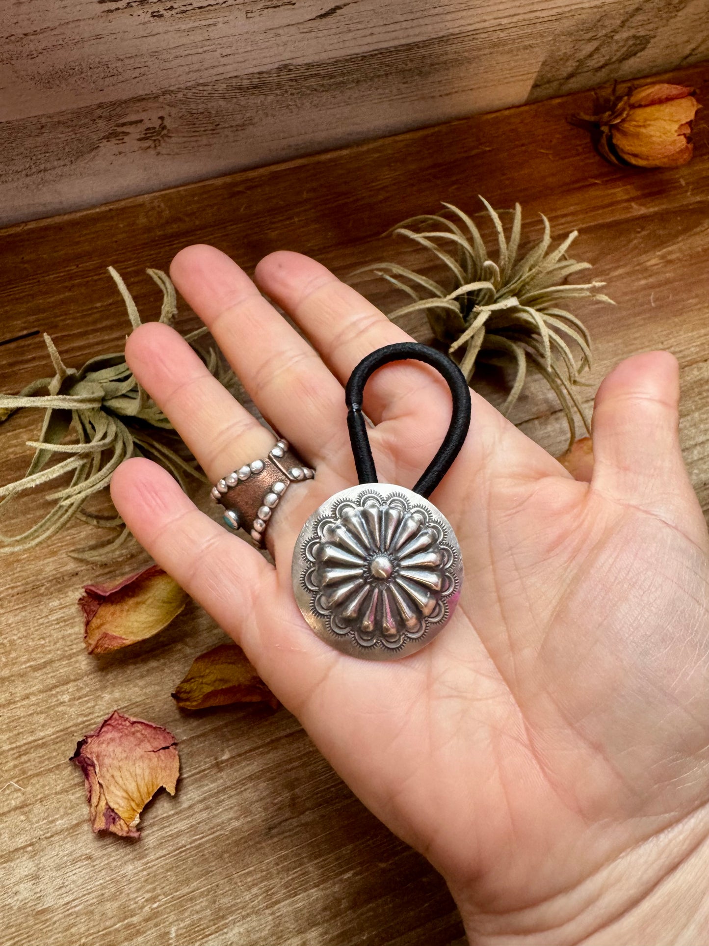Handmade sterling silver hair tie with a detailed stamped concho design. Each piece is unique due to individual stamping. Western style accessory, made in the USA. Curated by The Bijoux FAB.