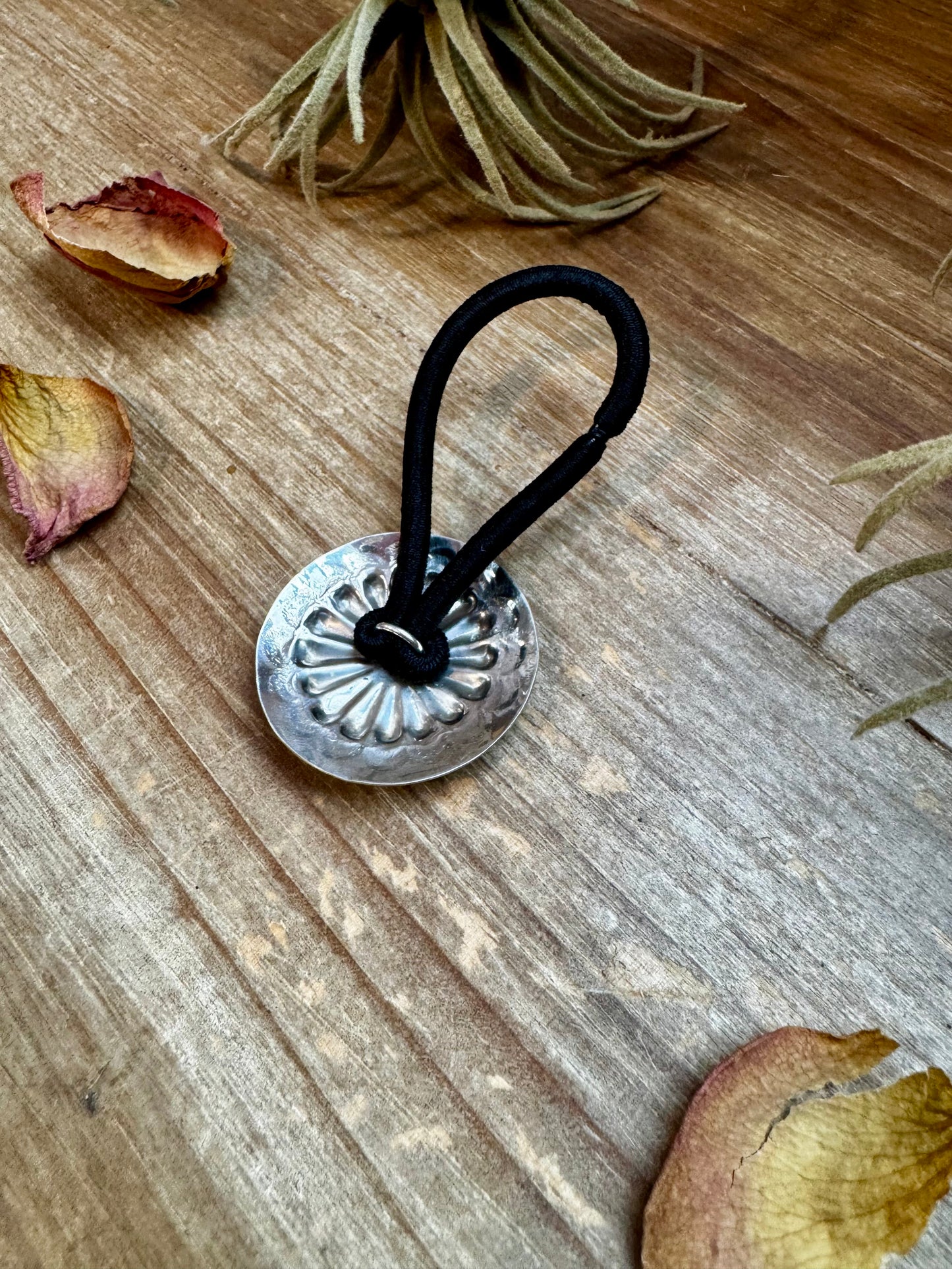 Handmade sterling silver hair tie with a detailed stamped concho design. Each piece is unique due to individual stamping. Western style accessory, made in the USA. Curated by The Bijoux FAB.