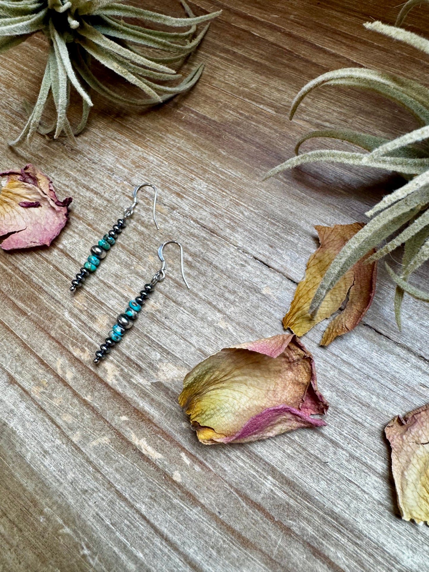 Close-up of handmade turquoise rondelle earrings with sterling silver beads and hooks, under 1.5 inches long