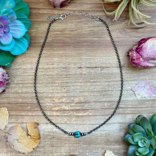 Dark blue turquoise oval necklace with sterling silver saucer pearls on black chain
