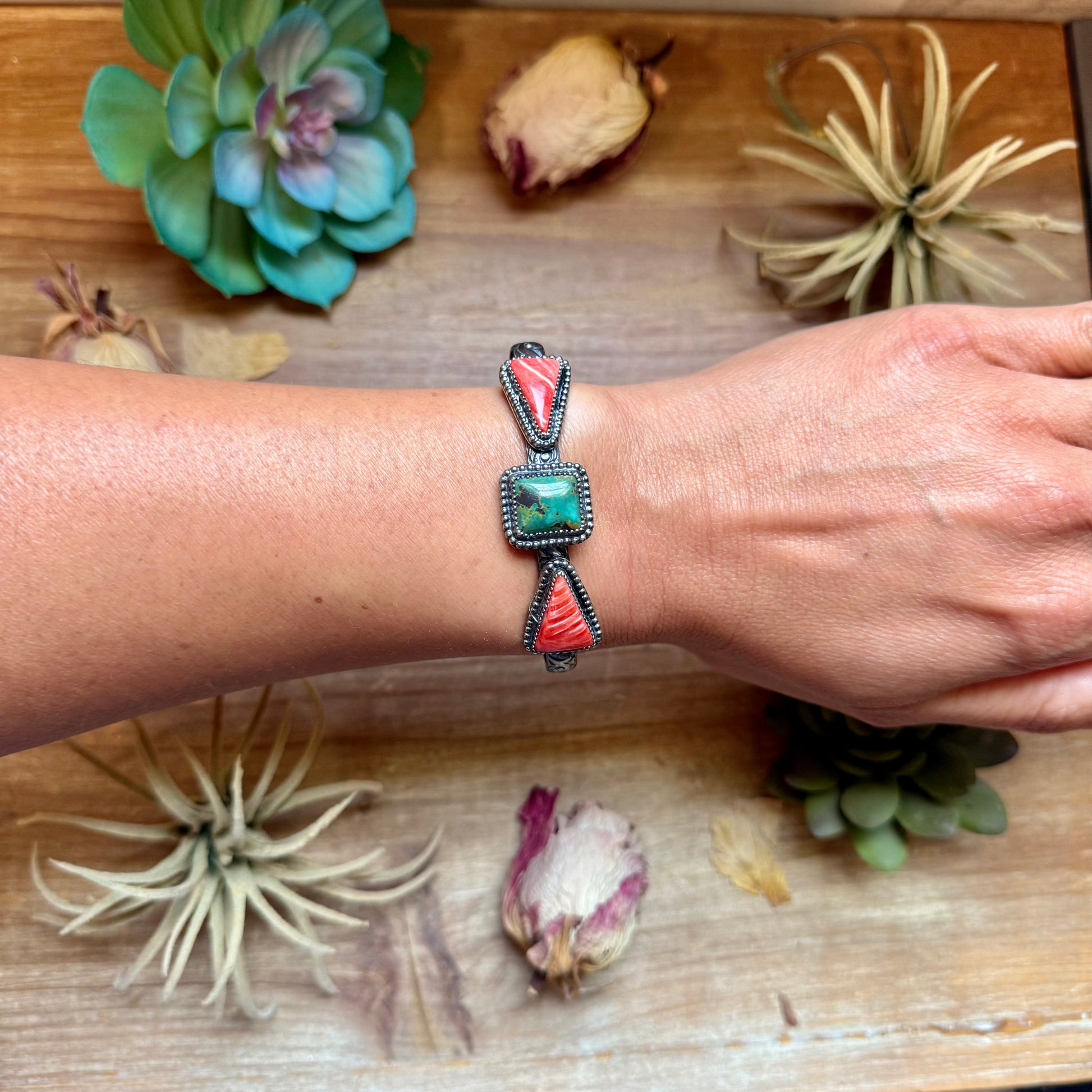 Handcrafted sterling silver cuff by MJ featuring a square green turquoise stone accented by red spiny oyster teardrop stones.