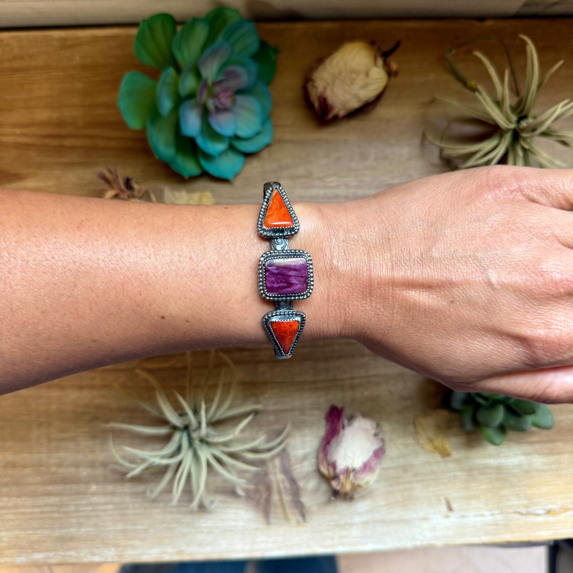 Handcrafted sterling silver cuff by MJ featuring a square purple spiny oyster stone with red spiny oyster accents.