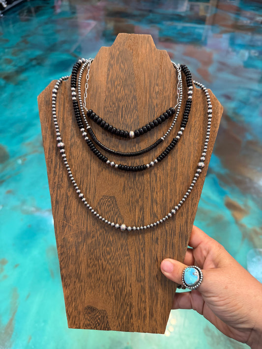 Black onyx and sterling silver layered necklace stack with paperclip chain, heishi beads, and graduated silver pearls handmade in the USA